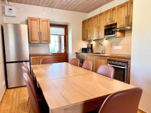 Il comprend une cuisine équipée d'une table en bois et d'un réfrigérateur. dans l'établissement Krüüdneri puhkemaja, à Krüüdneri