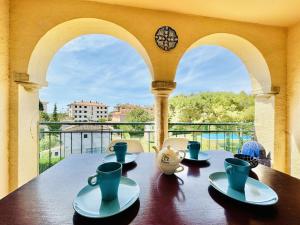 a table with cups and saucers on a balcony at Mimoses CostaBravaSi in Sant Feliu de Guíxols