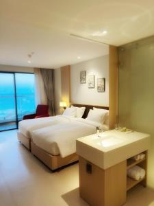 um quarto de hotel com uma cama e um lavatório em Helo!The Arena em Miếu Ông