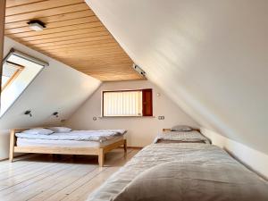 2 camas en un dormitorio ático con techos de madera en Krüüdneri puhkemaja en Krüüdneri