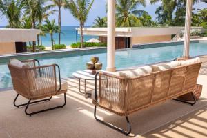two wicker chairs and a table next to a swimming pool at Villa Boonta in Phuket Town +79 photos
