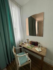 a desk with a mirror and a chair in a room at La Bonne Maison 3 in Troyes