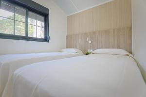 uma fila de camas num quarto com uma janela em Camping Urbion em Abejar