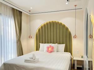 Un dormitorio con una cama grande con una flor. en The Royal Homies - Phu My Hung en Ho Chi Minh