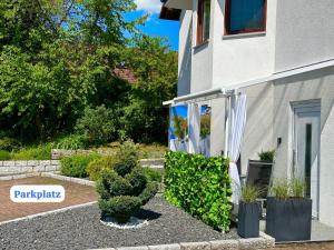 um jardim com plantas e uma cortina branca ao lado de um edifício em La Pura Vida em Bühlertann