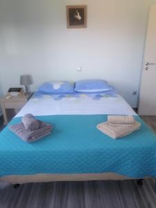 sypialnia z łóżkiem z ręcznikami w obiekcie casaeudokia w mieście Apóllona