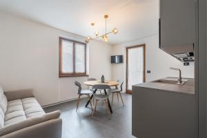 a kitchen and living room with a table and a couch at Residence Alessio in Ledro
