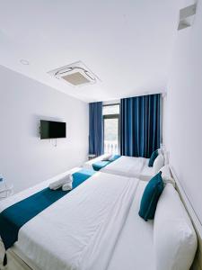 een slaapkamer met 2 bedden en blauwe kussens bij Beach Hotel Grand World (La La Homestay) in Phu Quoc