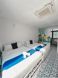 2 camas en una habitación de color azul y blanco en Beach Hotel Grand World (La La Homestay), en Phu Quoc