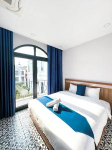 een slaapkamer met een groot bed en een groot raam bij Beach Hotel Grand World (La La Homestay) in Phu Quoc