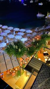 HOTEL DENOEL في كساميل: اطلالة علوية على شاطئ به مظلات وطاولات