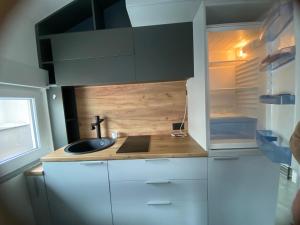 eine kleine Küche mit Spüle und Kühlschrank in der Unterkunft apartman HAJLA in Rožaje