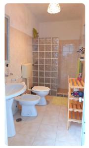 a bathroom with two toilets and a sink at Anexo na Quintinha in Caldas da Rainha