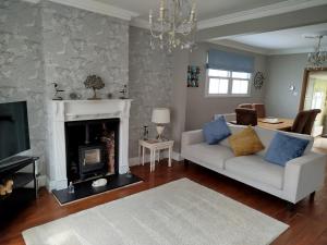 a living room with a white couch and a fireplace at 3 Bedroom Cottage in Sunninghill, Ascot in Sunninghill