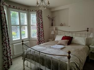 ein Schlafzimmer mit einem Bett und einem großen Fenster in der Unterkunft 3 Bedroom Cottage in Sunninghill, Ascot in Sunninghill