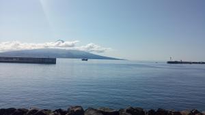 a large body of water with a mountain in the background at O Refúgio do Pim in Horta