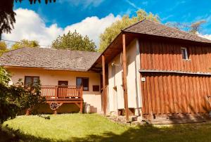 a wooden house with a porch and a deck at Tradičná kopaničiarska chalupa in Košariská-Priepasné