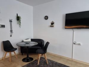 a room with a table and two chairs and a television at Paradise Gardens, sweet Apartment in Limassol