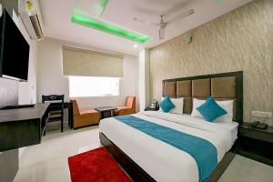 Hotel Atlantis suites Near Delhi Airport في نيودلهي: غرفة نوم مع سرير كبير مع مكتب ومكتب