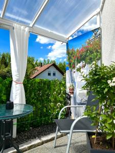 eine Terrasse mit einem Tisch und einer weißen Pergola in der Unterkunft La Pura Vida in Bühlertann