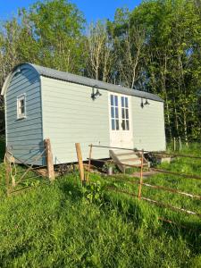 a tiny house is sitting in a field at Maddoc's Hut - Herefordshire in Hereford