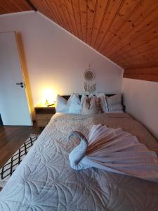 ein Schlafzimmer mit einem Bett mit einem Schwan darauf in der Unterkunft Mészi Vendégház in Zalacsány