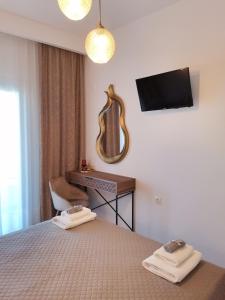 a bedroom with a bed and a desk and a television at Litsa Studios in Patitiri