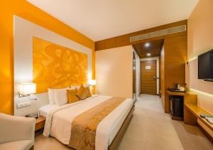 ニューデリーにあるHotel Atlantis suites Near Delhi Airportの大型ベッドとテレビが備わるホテルルームです。
