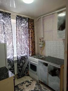 a kitchen with a stove top oven in a room at Люкс квартира в центре in Taraz