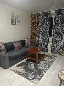 a living room with a couch and a table at Люкс квартира в центре in Taraz