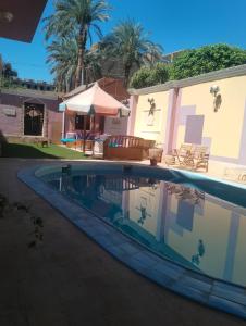uma piscina em frente a uma casa em Hoppa Guest House Nile View em Luxor
