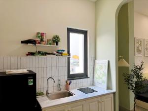 a kitchen with a sink and a window at Corgi House Danang in Danang