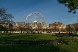 a ferris wheel in a park in front of a building at MBA Splendide Appart - Tracy 1 - Proche du Musée du Louvre in Paris