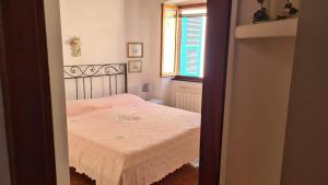 a small bedroom with a bed with a pink blanket at La Terrazza sul Mare Sea View - near best beaches in Monterosso al Mare