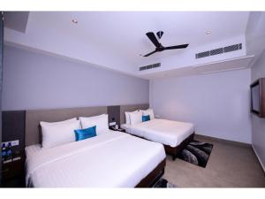 een hotelkamer met 2 bedden en een plafond bij Belvedere Suites in Greater Noida