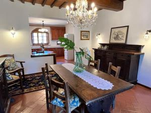 a dining room table with a vase of flowers on it at Villa Il Signorino in Lucolena in Chianti +24 photos