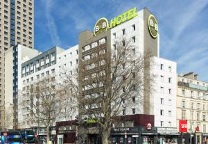 un bâtiment avec une horloge sur son côté dans l'établissement B&B HOTEL Paris Porte de la Villette, à Paris