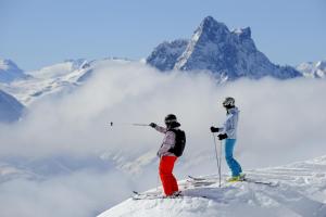 dos personas de pie en la cima de una montaña cubierta de nieve en Hotel Sonnblick, en Wald am Arlberg