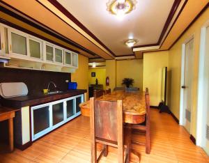 a kitchen with a wooden table and a dining room at Jewel Igorot Building in Baguio