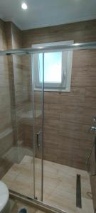 W łazience znajduje się prysznic ze szklanymi drzwiami. w obiekcie Nikolas House w mieście Arillas