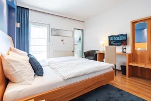 A bed or beds in a room at Das Blaufränkisch Weinhotel & Restaurant