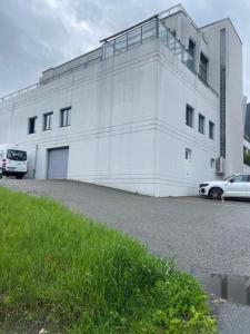 un edificio bianco con macchine parcheggiate di fronte di Studio Glishorn Blick a Brig