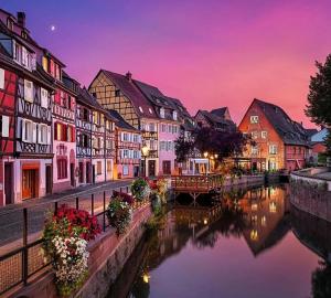 a group of buildings next to a river at L'Altenberg in Bergheim