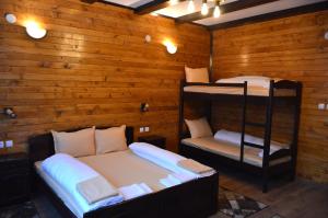2 łóżka piętrowe w pokoju z drewnianymi ścianami w obiekcie Ваканционно селище Ива w mieście Syrnica