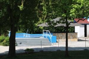 Tulipán Camping في جينيسدياس: مجموعة من السلالم مع مظلة بجوار حمام السباحة