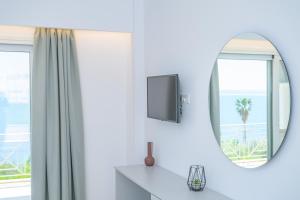 a bathroom with a mirror and a tv and a window at KOSTA MARIA in Paleros