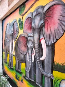 a painting of two elephants on a wall at Hotel Shobha and Tent House in Patrātu