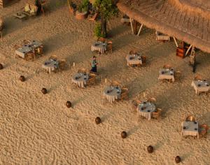 uma vista sobre uma praia com mesas e cadeiras em Jimbaran Puri, A Belmond Hotel, Bali em Jimbaran
