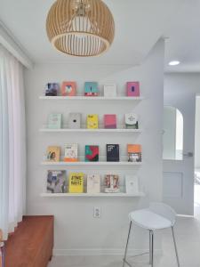 ポハンにあるCalmersの白い棚と本、椅子が備わる部屋