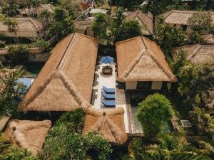an overhead view of a resort with umbrellas and a pool at Jimbaran Puri, A Belmond Hotel, Bali in Jimbaran